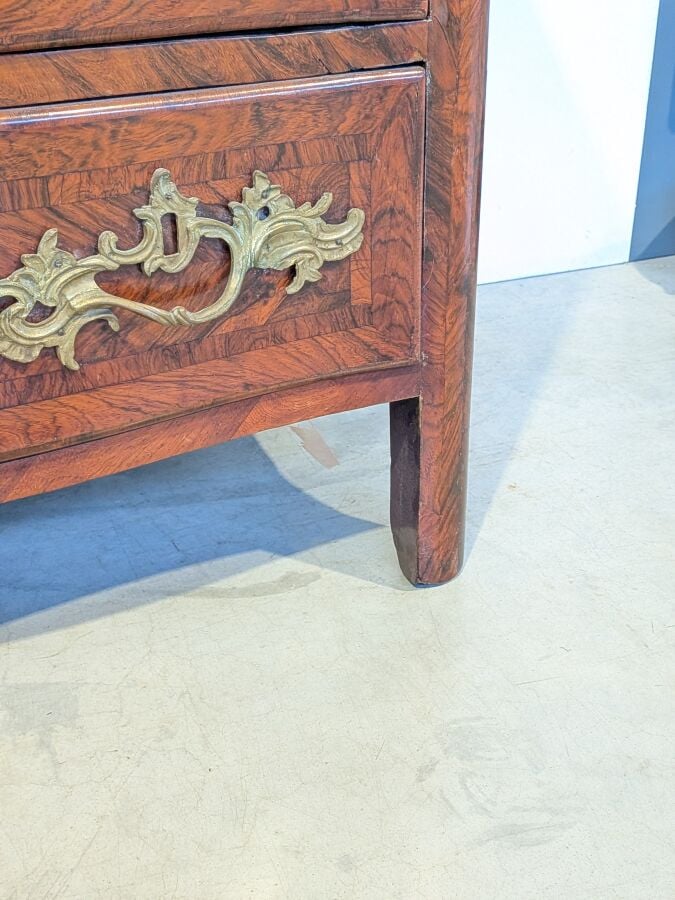 COMMODE galbée en placage de marqueterie ouvrant par trois tiroirs en façade ;…