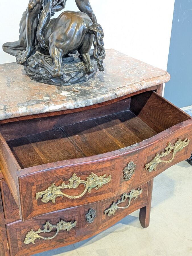 COMMODE galbée en placage de marqueterie ouvrant par trois tiroirs en façade ;…
