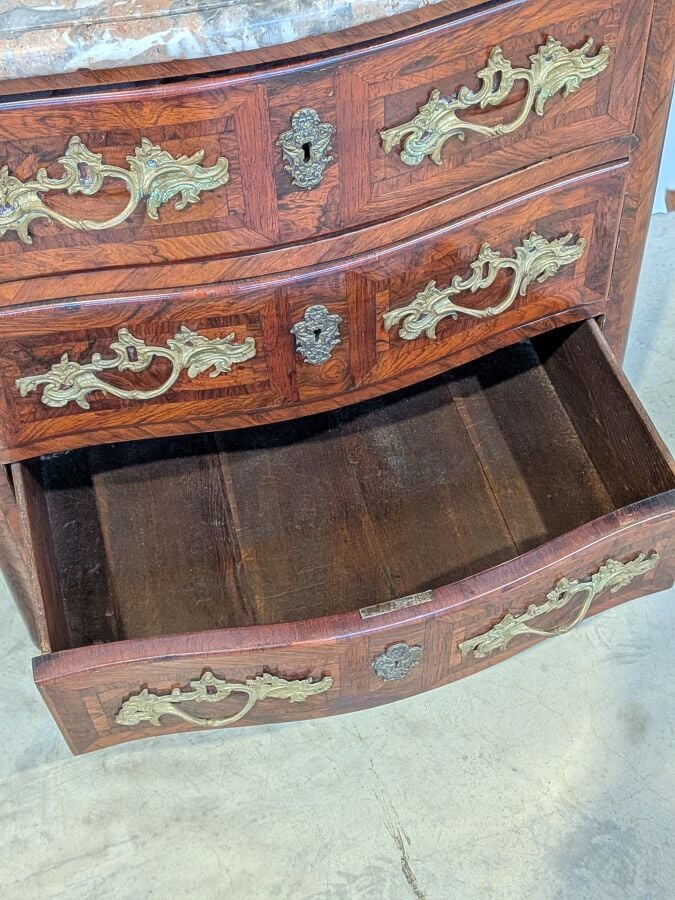 COMMODE galbée en placage de marqueterie ouvrant par trois tiroirs en façade ;…