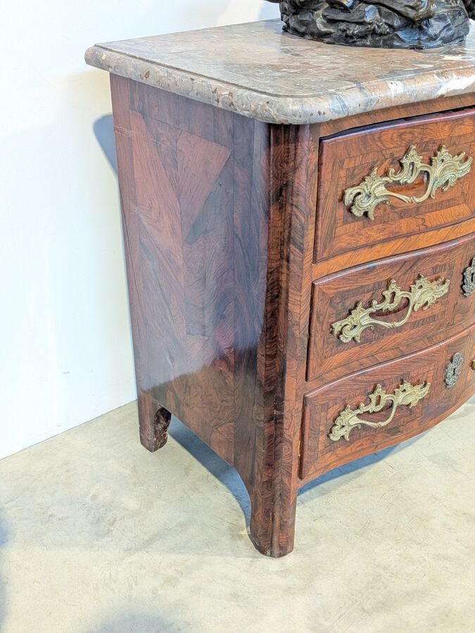 COMMODE galbée en placage de marqueterie ouvrant par trois tiroirs en façade ;…