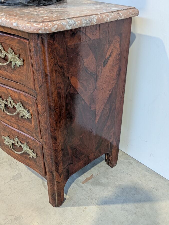 COMMODE galbée en placage de marqueterie ouvrant par trois tiroirs en façade ;…