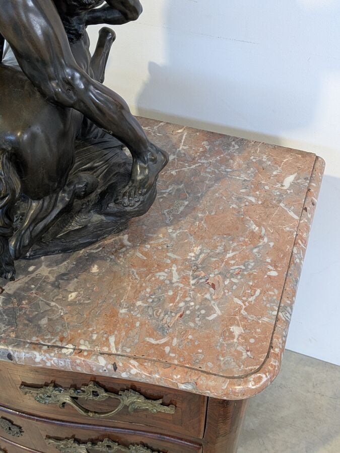 COMMODE galbée en placage de marqueterie ouvrant par trois tiroirs en façade ;…