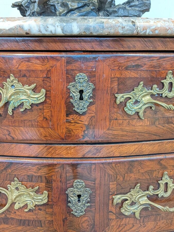 COMMODE galbée en placage de marqueterie ouvrant par trois tiroirs en façade ;…