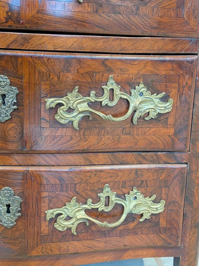 COMMODE galbée en placage de marqueterie ouvrant par trois tiroirs en façade ;…