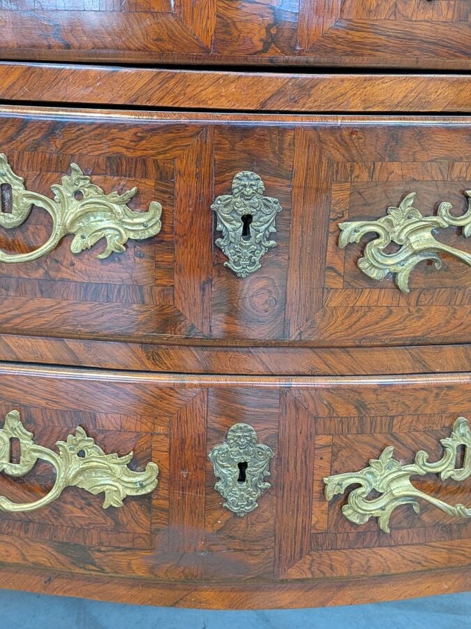COMMODE galbée en placage de marqueterie ouvrant par trois tiroirs en façade ;…