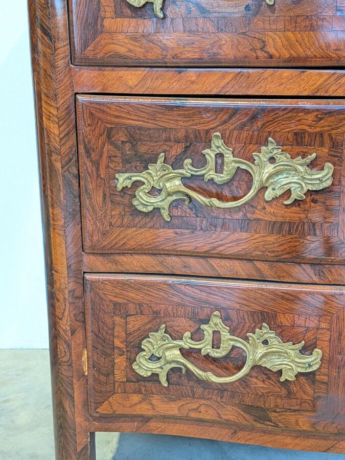 COMMODE galbée en placage de marqueterie ouvrant par trois tiroirs en façade ;…