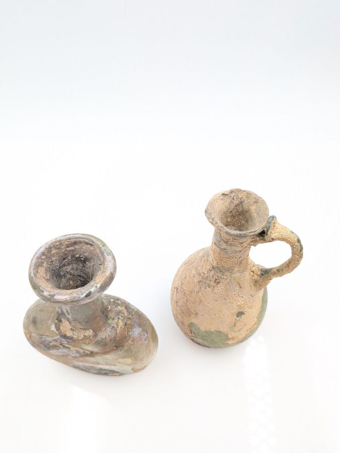 Cruche à panse piriforme. - Verre verdâtre partiellement irisé. (restaurations…