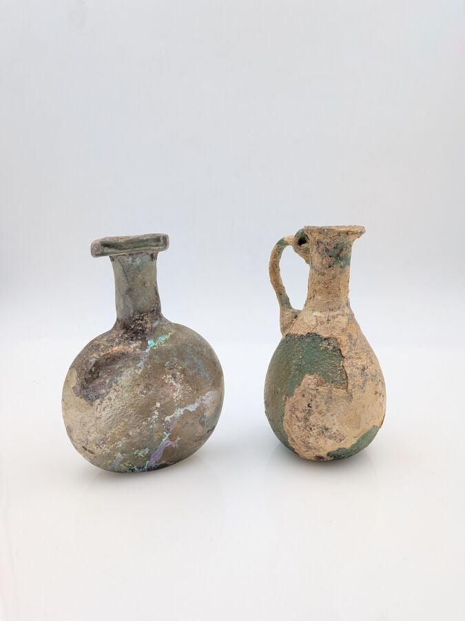 Cruche à panse piriforme. - Verre verdâtre partiellement irisé. (restaurations…