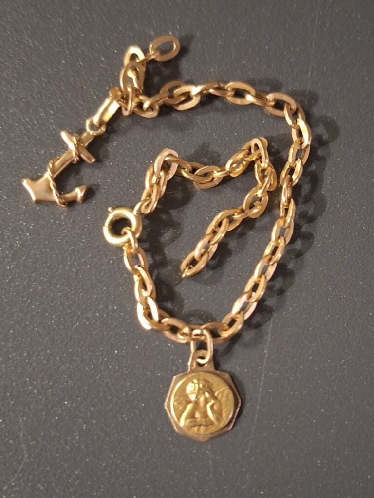 Gourmette en or jaune (750) à maille jaseron, avec petite médaille Angelot et a…