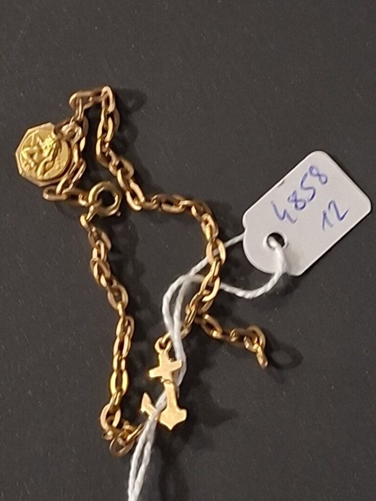 Gourmette en or jaune (750) à maille jaseron, avec petite médaille Angelot et a…