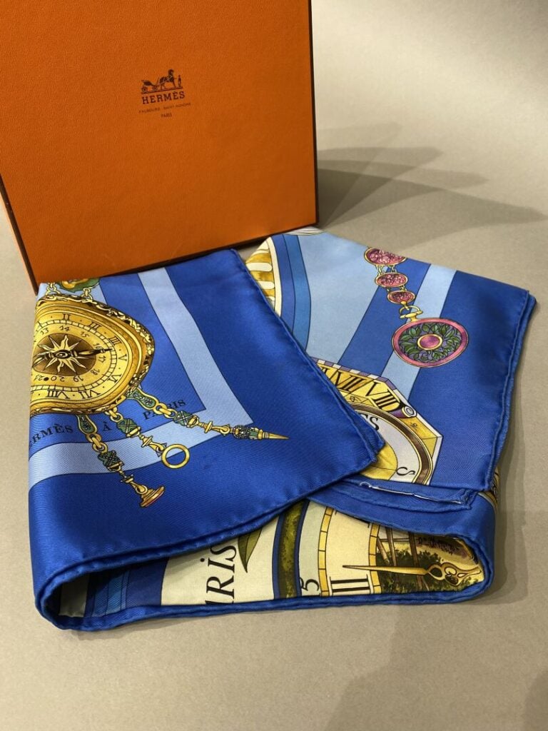 HERMES - Carré en twill de soie à décor imprimé titré La ronde des heures, fond…