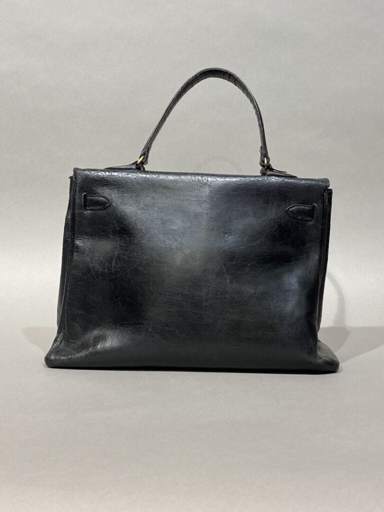 HERMÈS circa 1949 - Sac « Kelly 32 » en box noir. - Clefs sous clochette en cui…