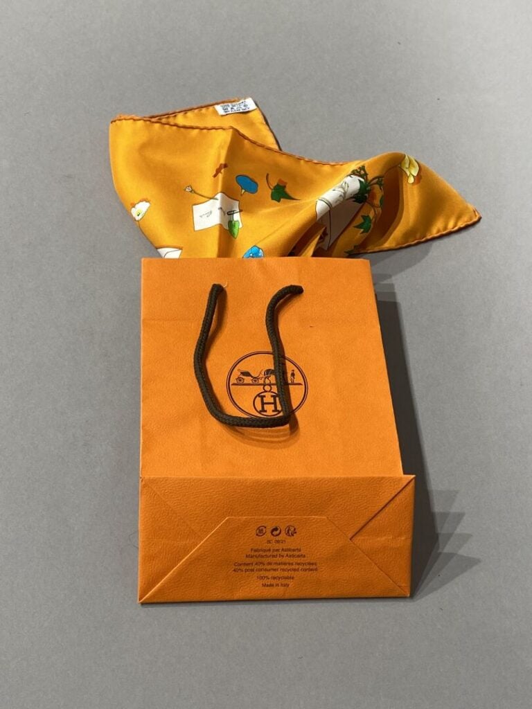 HERMÈS - Gavroche en twill de soie titré « Des fleurs pour le dire », sur fond…
