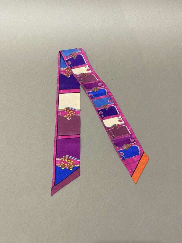 HERMÈS - Twilly « Camails » en soie imprimée fuschia, à décors de camails multi…