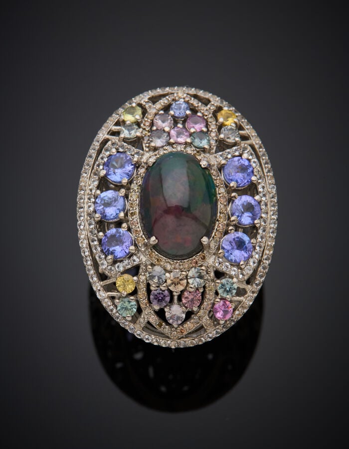 Importante BAGUE en argent (925‰) ajouré à motif de volutes, ornée d'une opale…