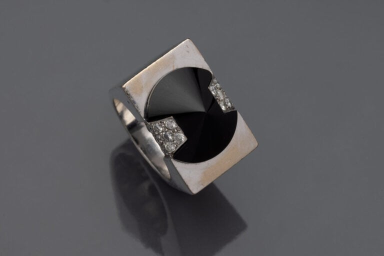 Large BAGUE rectangulaire en or gris 750°/°° surmontée d'un cône en onyx épaulé…