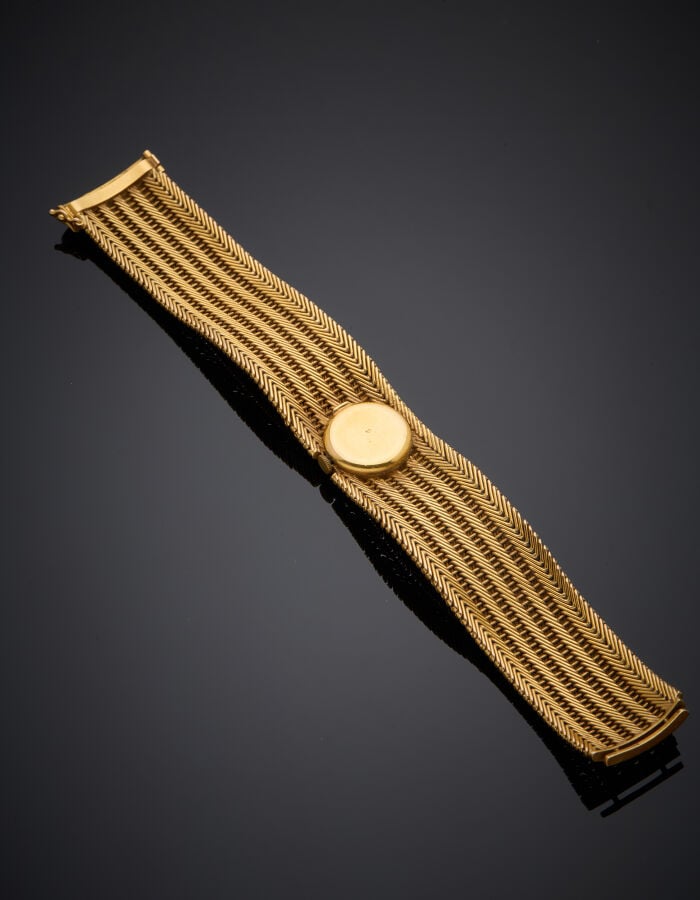 Large BRACELET MONTRE ronde de dame en or jaune (750‰). Cadran crème, index bât…