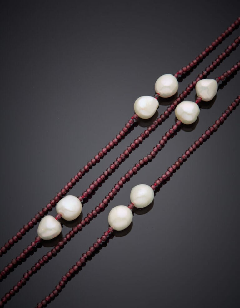Long SAUTOIR composé d'un rang de perles de grenats facettés, alternées de perl…