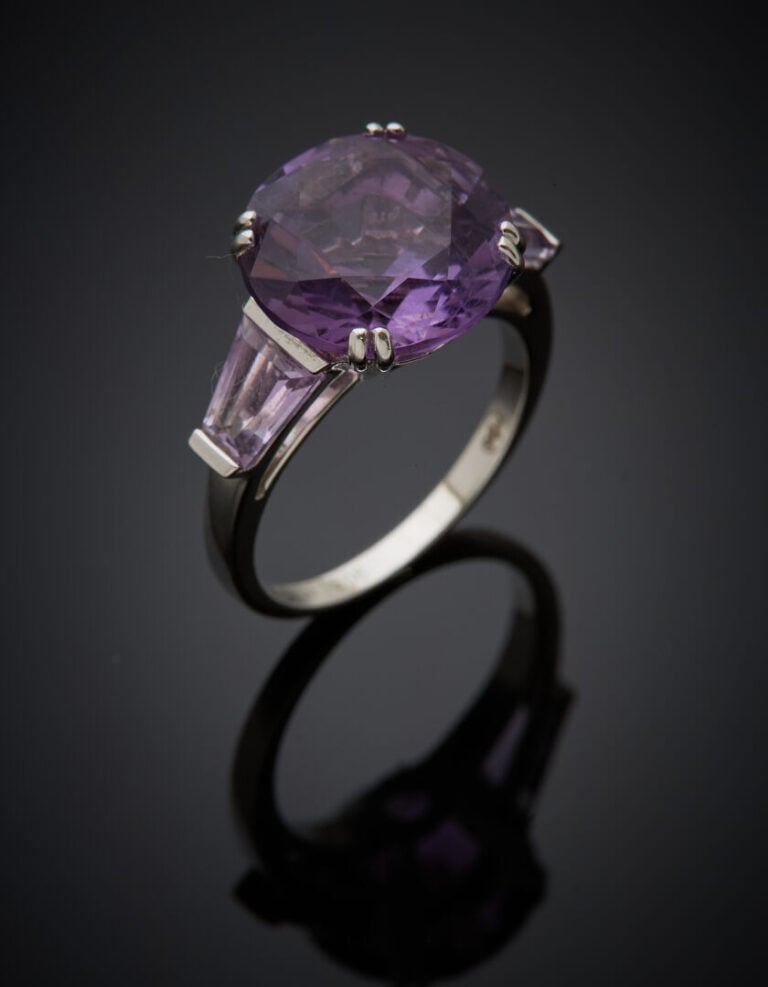 MAUBOUSSIN - BAGUE en or gris (750‰) serti d'une améthyste ronde épaulée de deu…