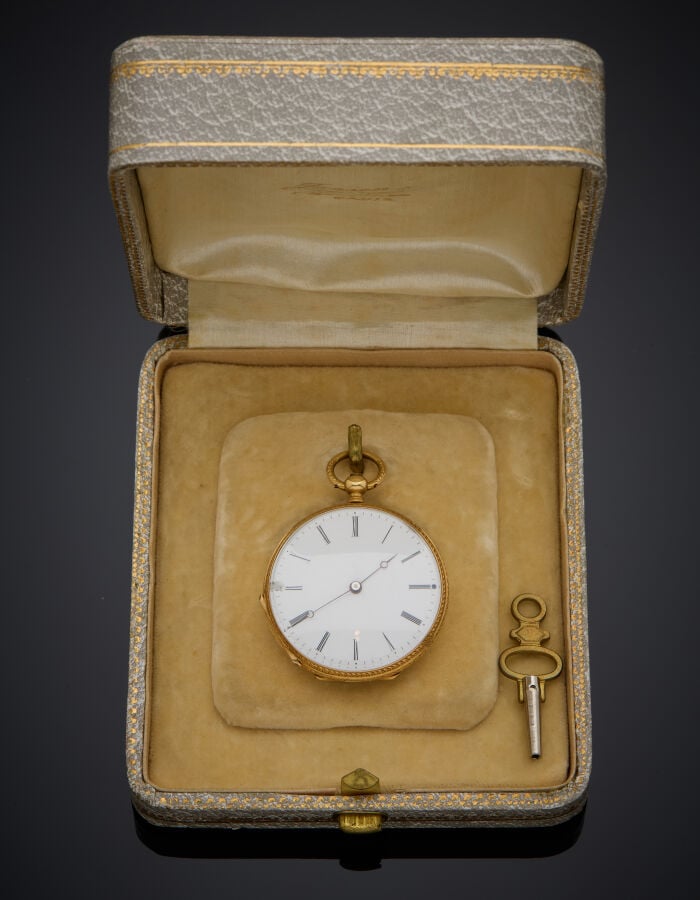 MONTRE de COL en or jaune (750‰) entièrement ciselé, orné d'émail noir à décor…