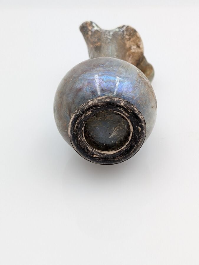 OEnochoé à lèvre pincée, à haut col et pied discoïde. Verre translucide violine…