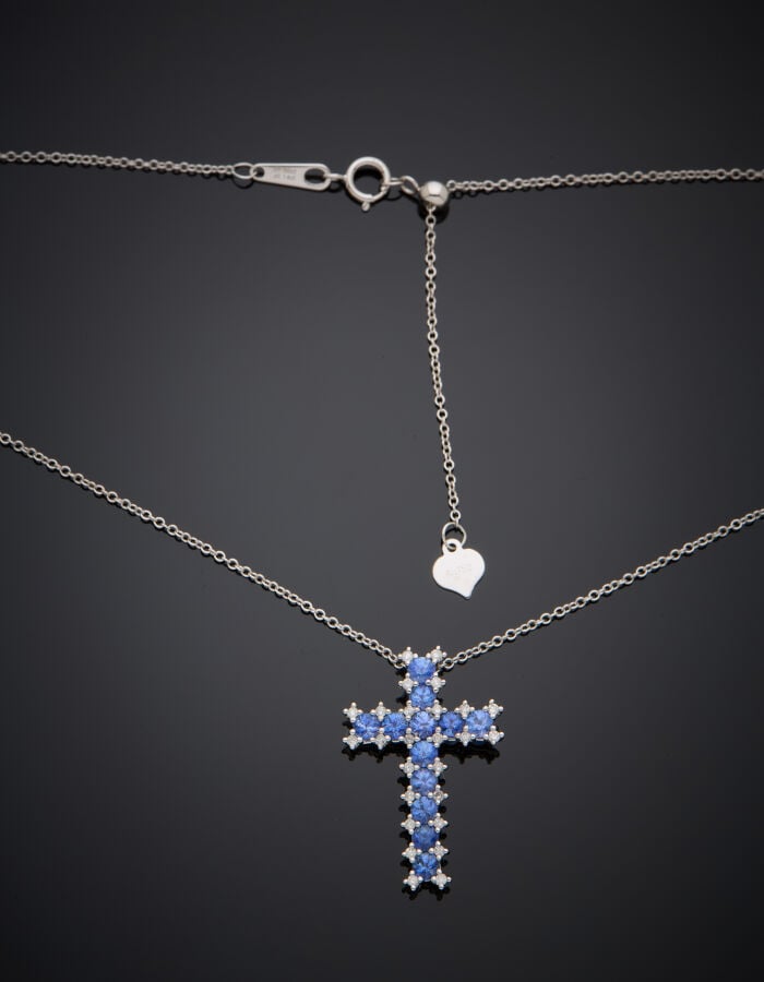 PENDENTIF "croix" et sa fine chaînette en or gris (750‰) serti de douze saphir…