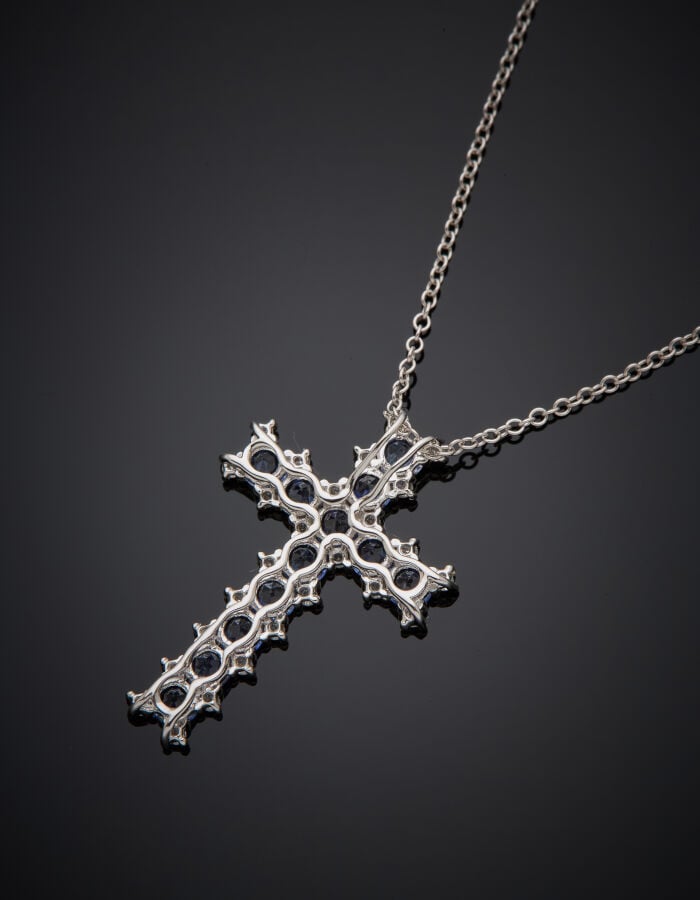 PENDENTIF "croix" et sa fine chaînette en or gris (750‰) serti de douze saphir…
