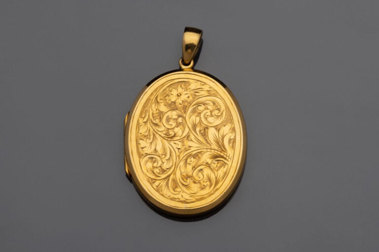 Pendentif médaillon porte-souvenir ovale en or jaune à décor ciselé d'enrouleme…