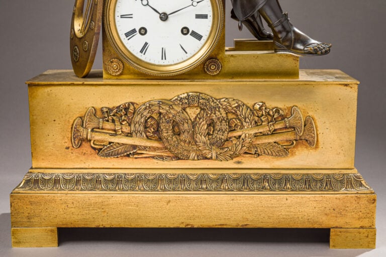 Pendule en bronze patiné et doré sommée d'un musicien tenant une Lyre dans sa m…