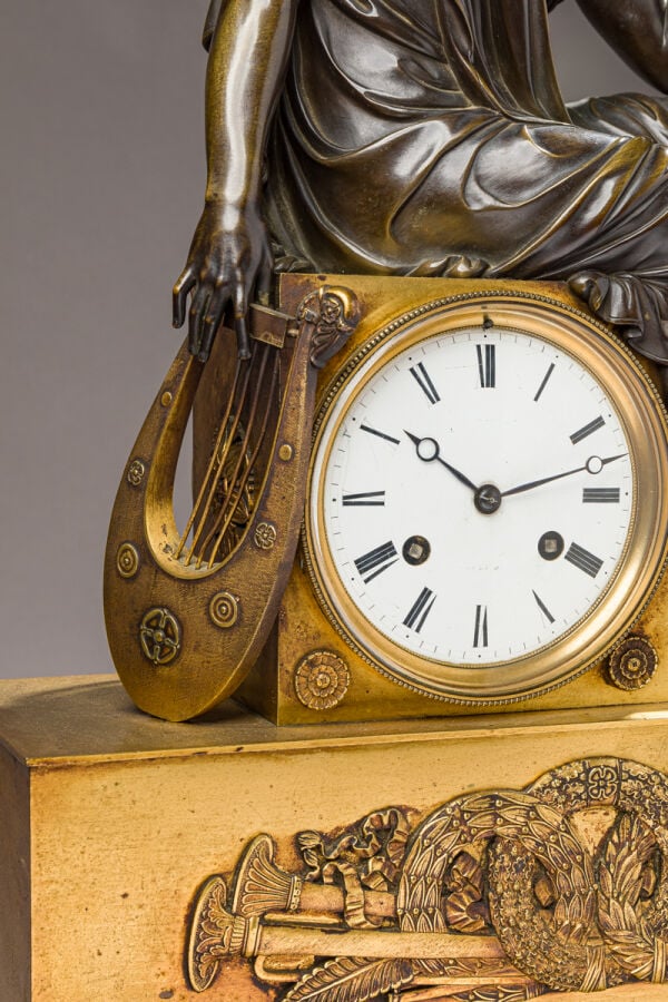 Pendule en bronze patiné et doré sommée d'un musicien tenant une Lyre dans sa m…