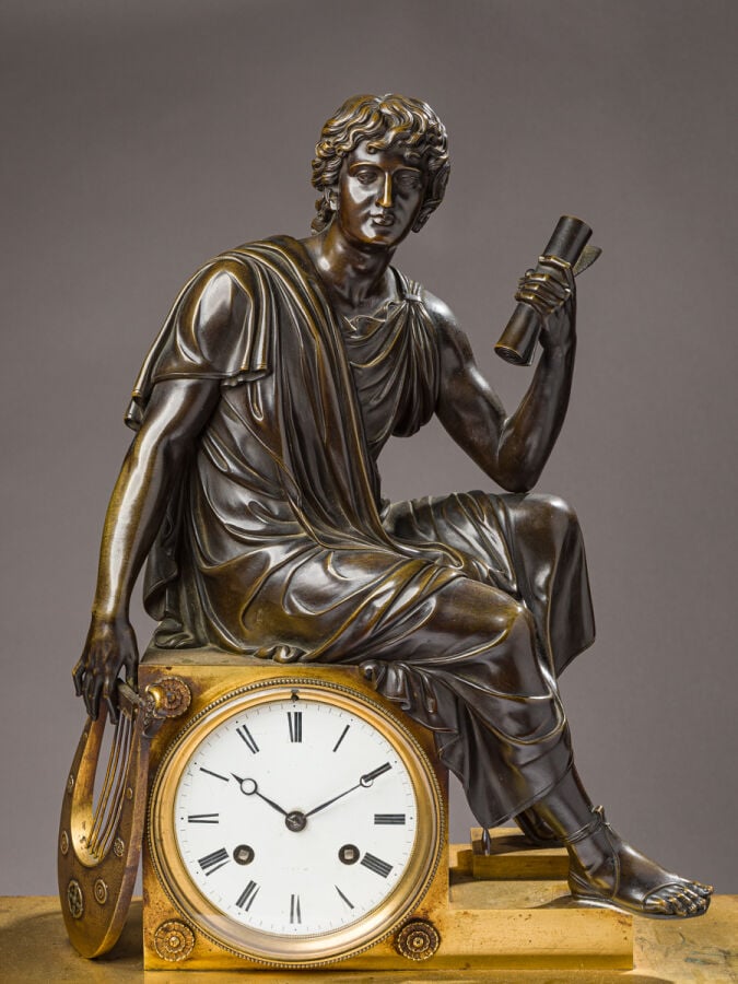 Pendule en bronze patiné et doré sommée d'un musicien tenant une Lyre dans sa m…