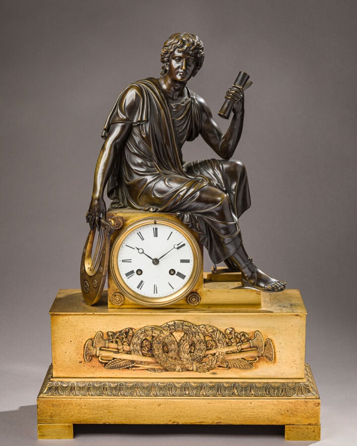 Pendule en bronze patiné et doré sommée d'un musicien tenant une Lyre dans sa m…