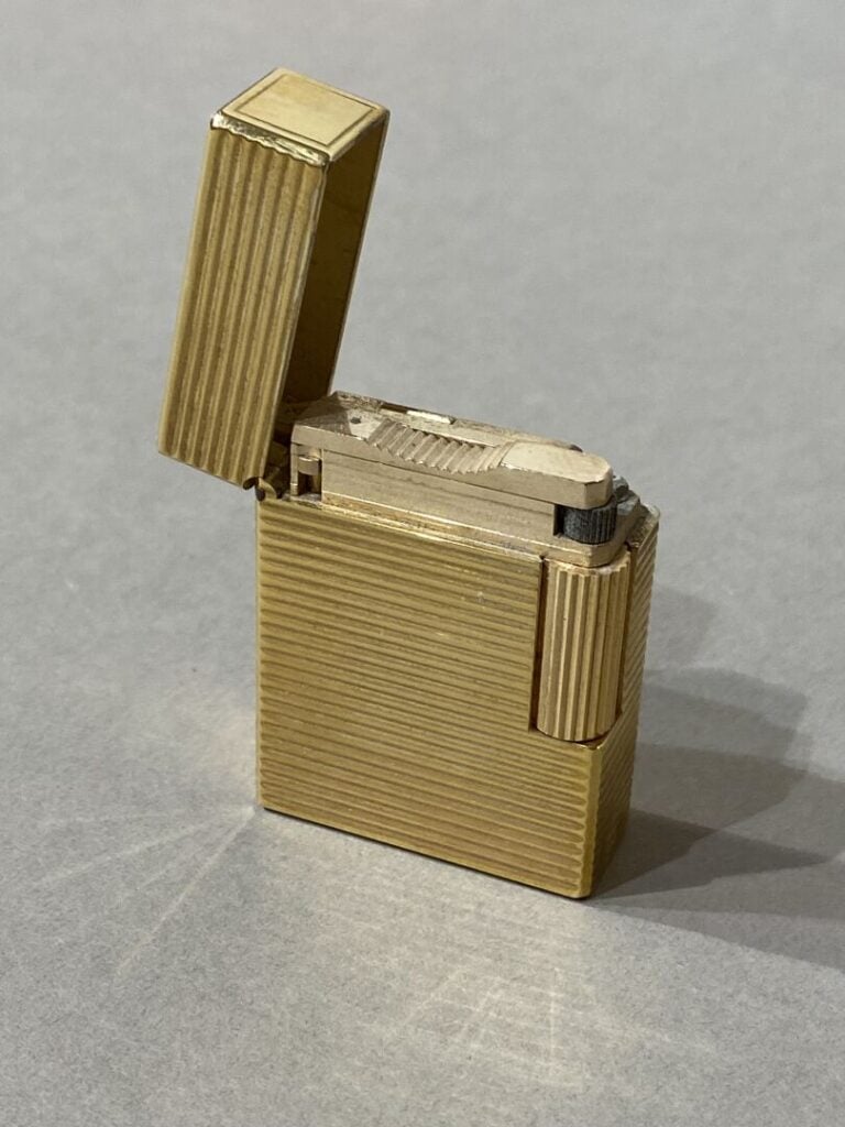S.T. DUPONT - BRIQUET en métal doré. - Signé S.T. DUPONT. Dans son écrin.