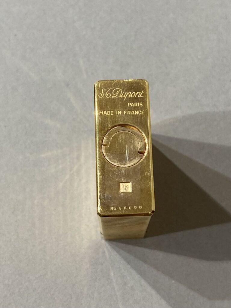 S.T. DUPONT - BRIQUET en métal doré. - Signé S.T. DUPONT. Dans son écrin.