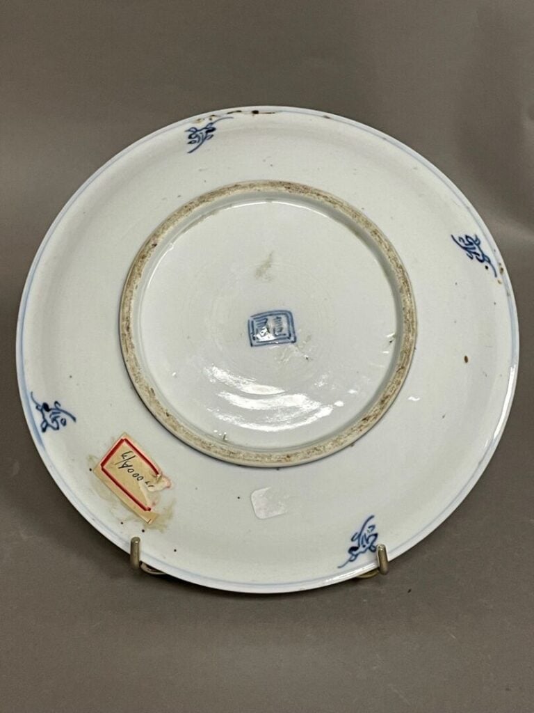 Assiette en porcelaine bleu et blanc orné d'un sceau au centre et de 2 frises b…