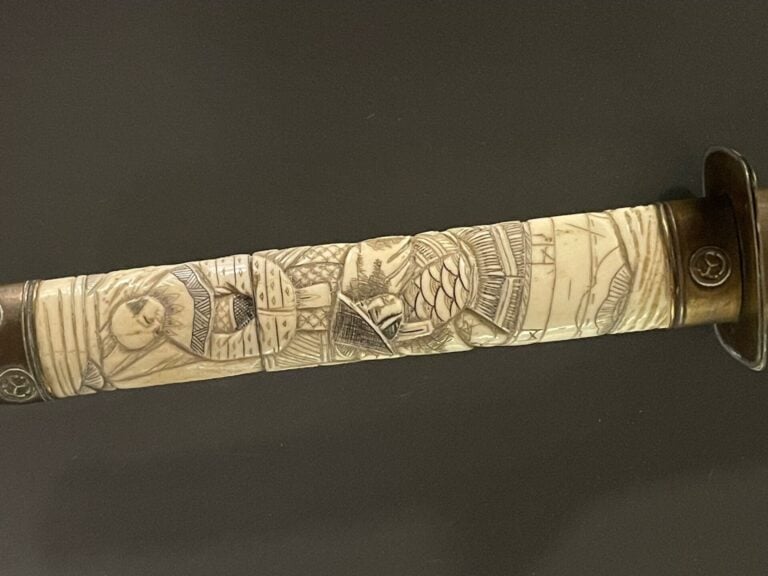 JAPON, vers 1920 - Wakizashi à lame courbe en os sculpté à décor de personnages…