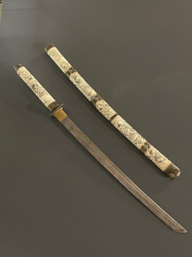 JAPON, vers 1920 - Wakizashi à lame courbe en os sculpté à décor de personnages…