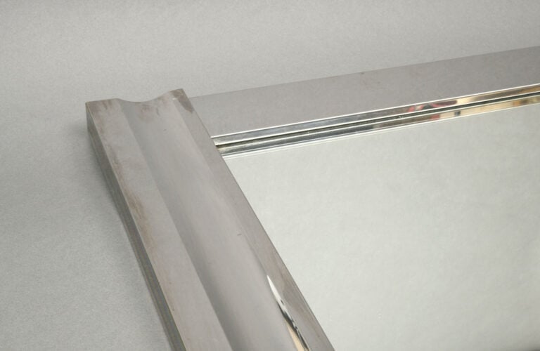 Miroir de forme carrée en métal chromé fixé sur bois, les montants légèrement c…