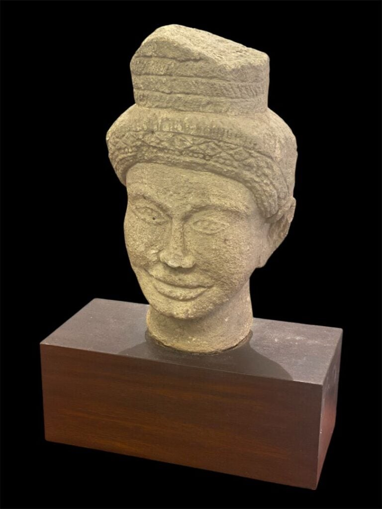 Style KHMER, XXe - Tête de Visnu en grès - Sur socle en bois - H. 42 cm