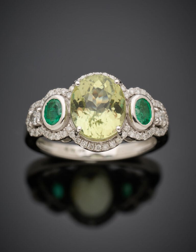 BAGUE en or gris (375°/°°) 9 carats, serti d'une scapolite ovale, épaulée d'éme…