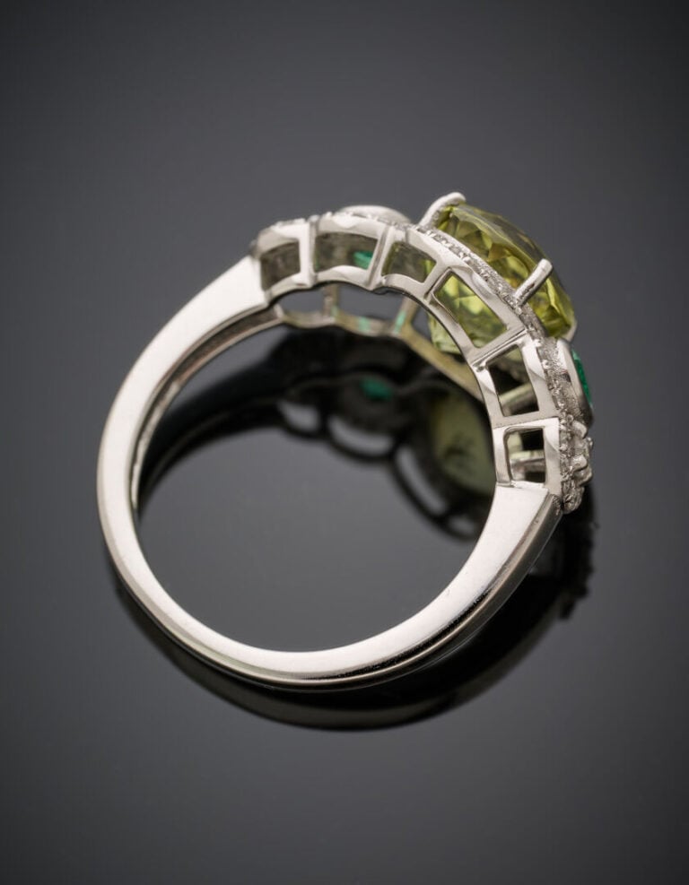 BAGUE en or gris (375°/°°) 9 carats, serti d'une scapolite ovale, épaulée d'éme…