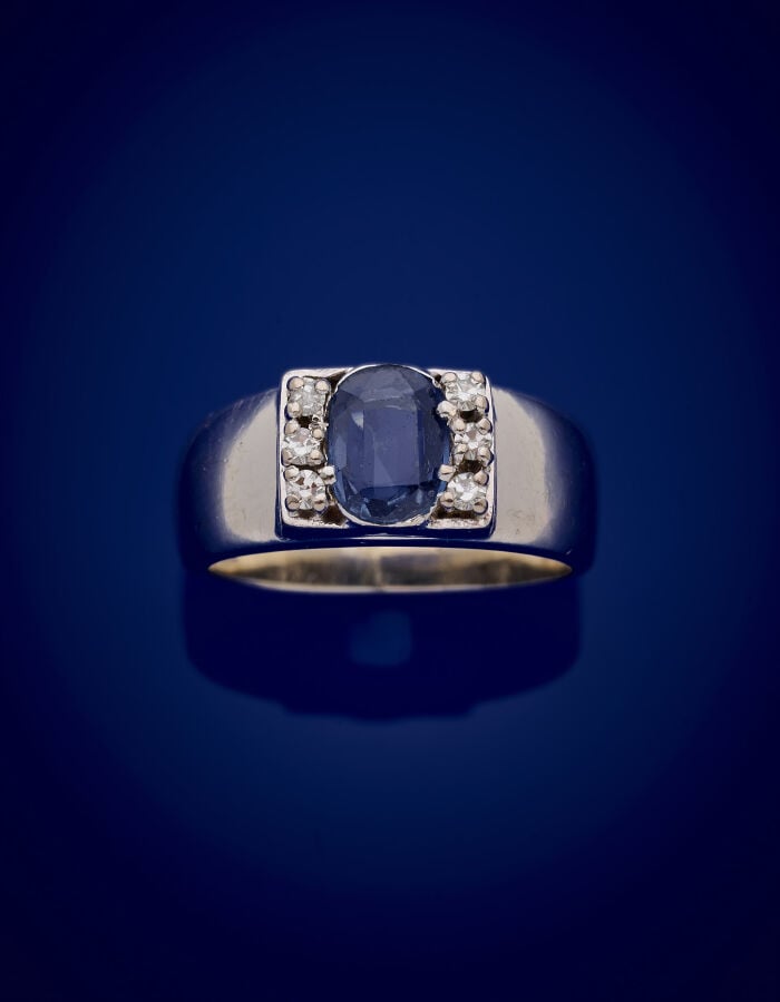 BAGUE en or gris (750‰) serti d'une pierre bleue (égrisures), épaulée de six pa…