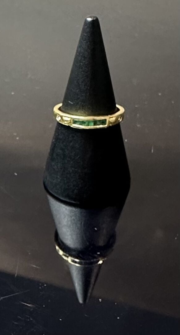 Bague en or jaune (750) centrée d'un alignement d'emeraudes taillées à degrés e…