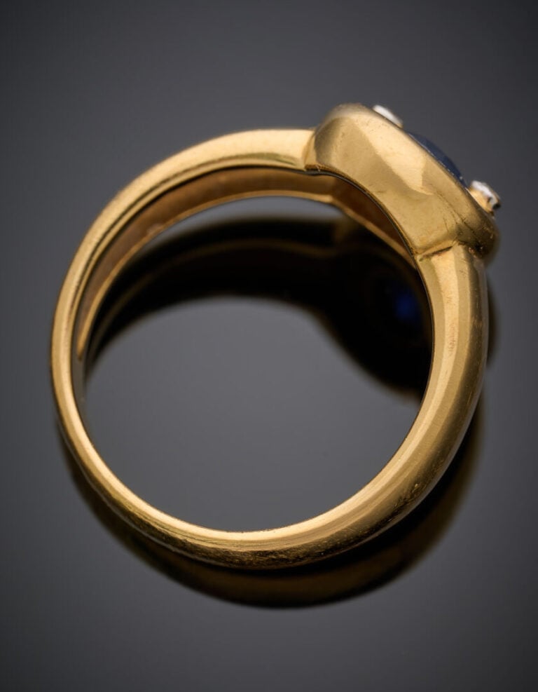 BAGUE en or jaune (750°/°°) centrée d'un saphir ovale en serti clos épaulé de d…