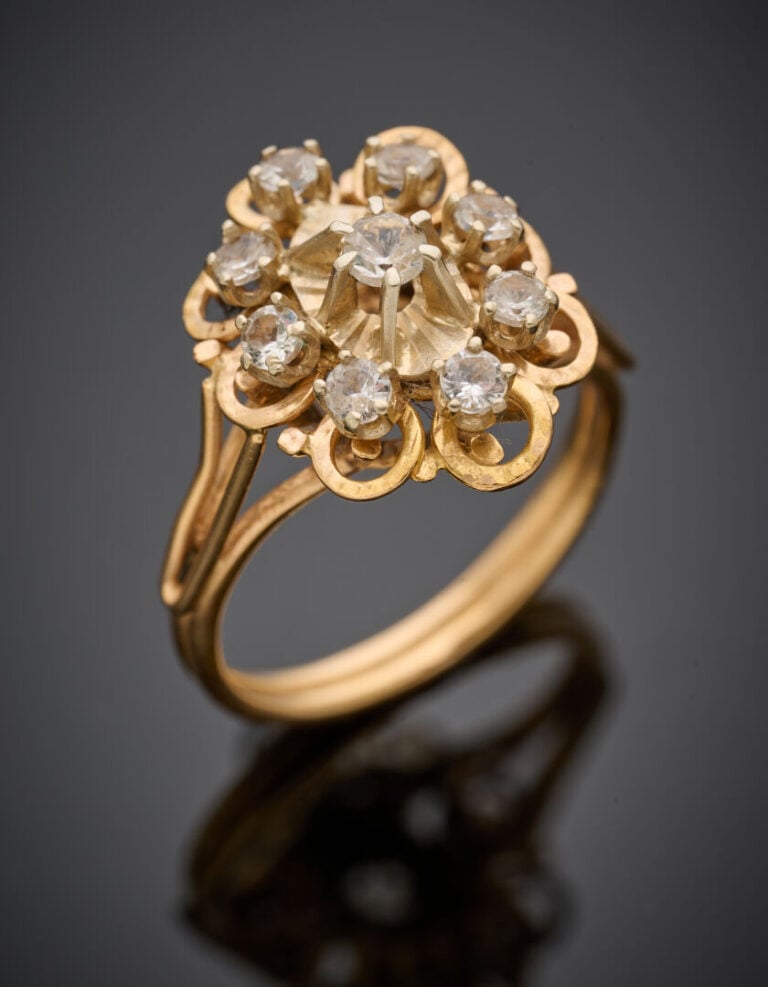 BAGUE "fleur" en or jaune (750°/°°) ciselé serti de 9 pierres blanches. - Doigt…