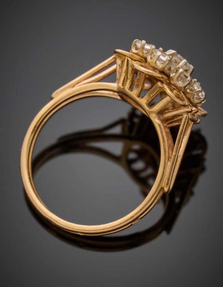 BAGUE "fleur" en or jaune (750°/°°) ciselé serti de 9 pierres blanches. - Doigt…