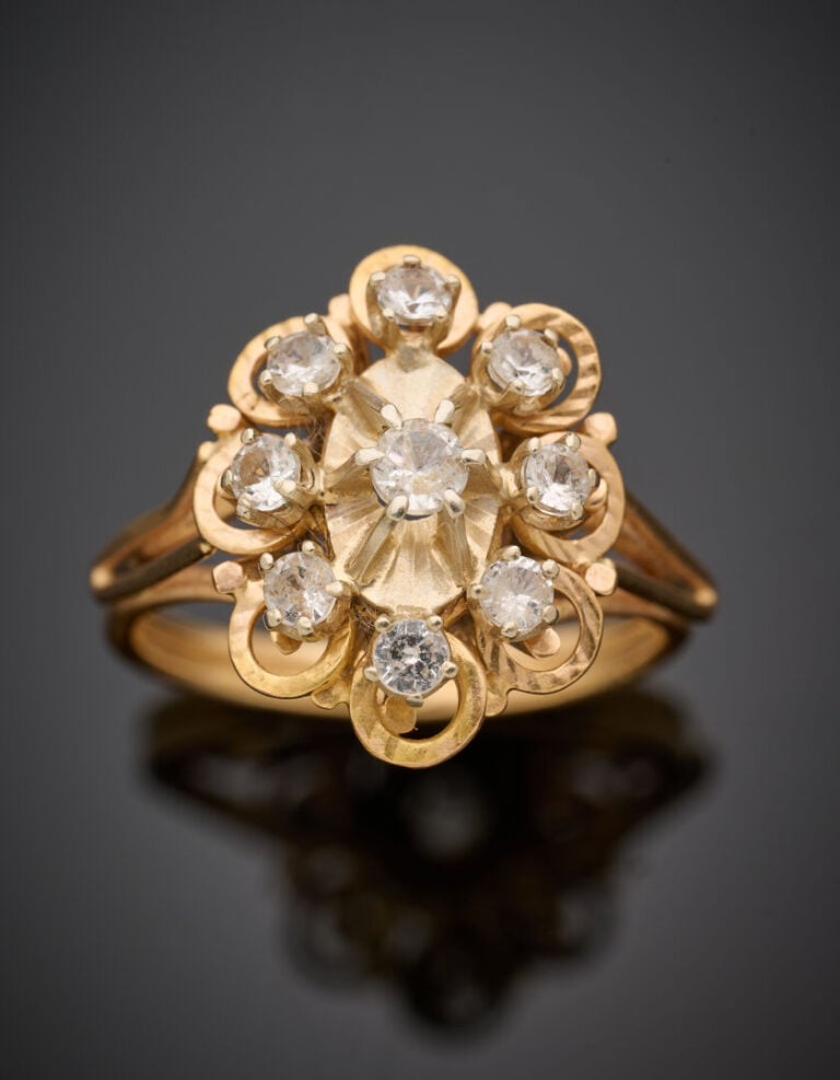 BAGUE "fleur" en or jaune (750°/°°) ciselé serti de 9 pierres blanches. - Doigt…
