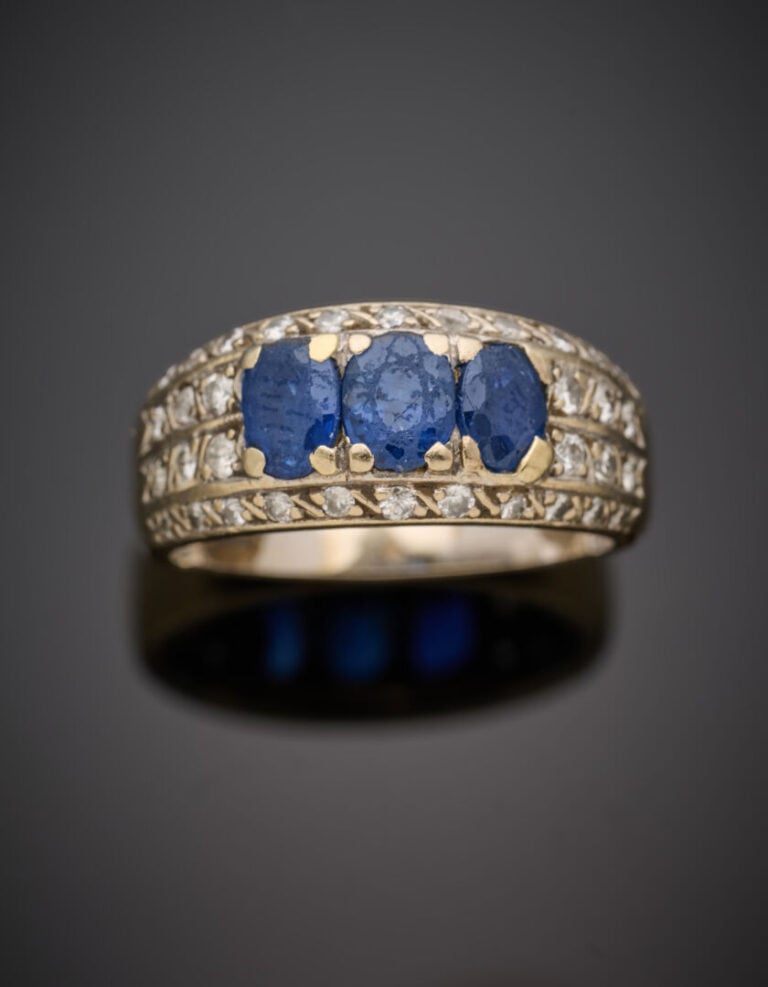 BAGUE "jonc" en or gris (750°/°°) serti d'un alignement de trois saphirs de for…