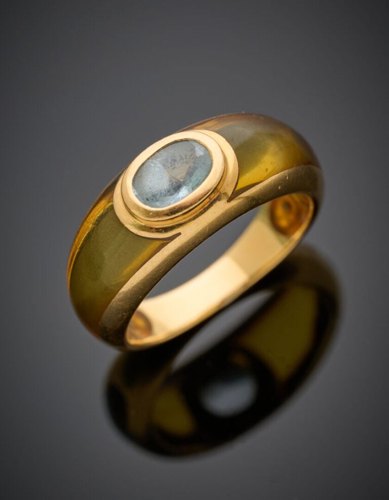 BAGUE jonc en or jaune (750‰) et résine jaune, centrée d'une topaze bleue suifé…