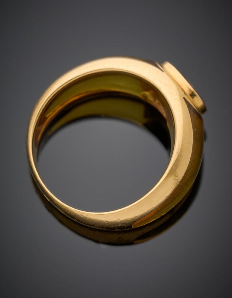BAGUE jonc en or jaune (750‰) et résine jaune, centrée d'une topaze bleue suifé…
